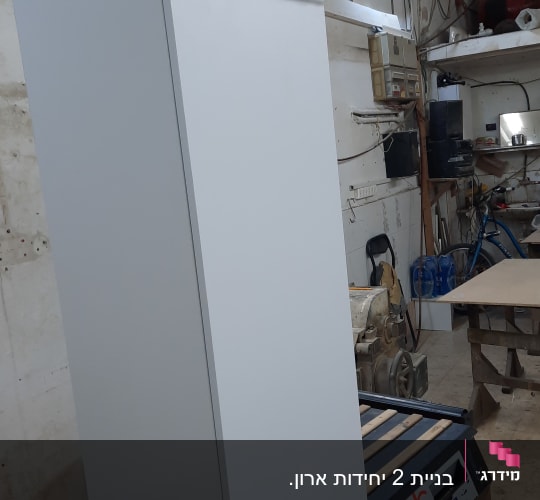 ארון לבן על שולחן עבודה בנגריה עם תאורה עליונה